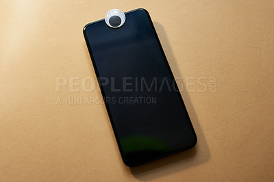 Buy stock photo Studio shot of an eye covering the webcam on a smartphone against a brown background