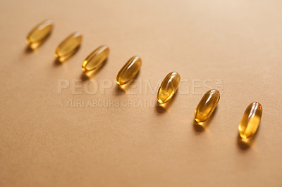 Buy stock photo Studio shot of gel capsules against a brown background