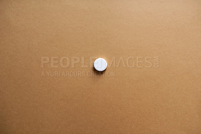 Buy stock photo Studio shot of a single white tablet against a brown background