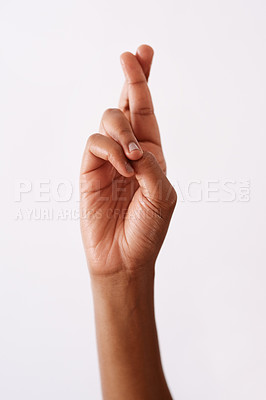 Buy stock photo Studio shot of an unrecognizable woman's hand keeping fingers crossed against a white background