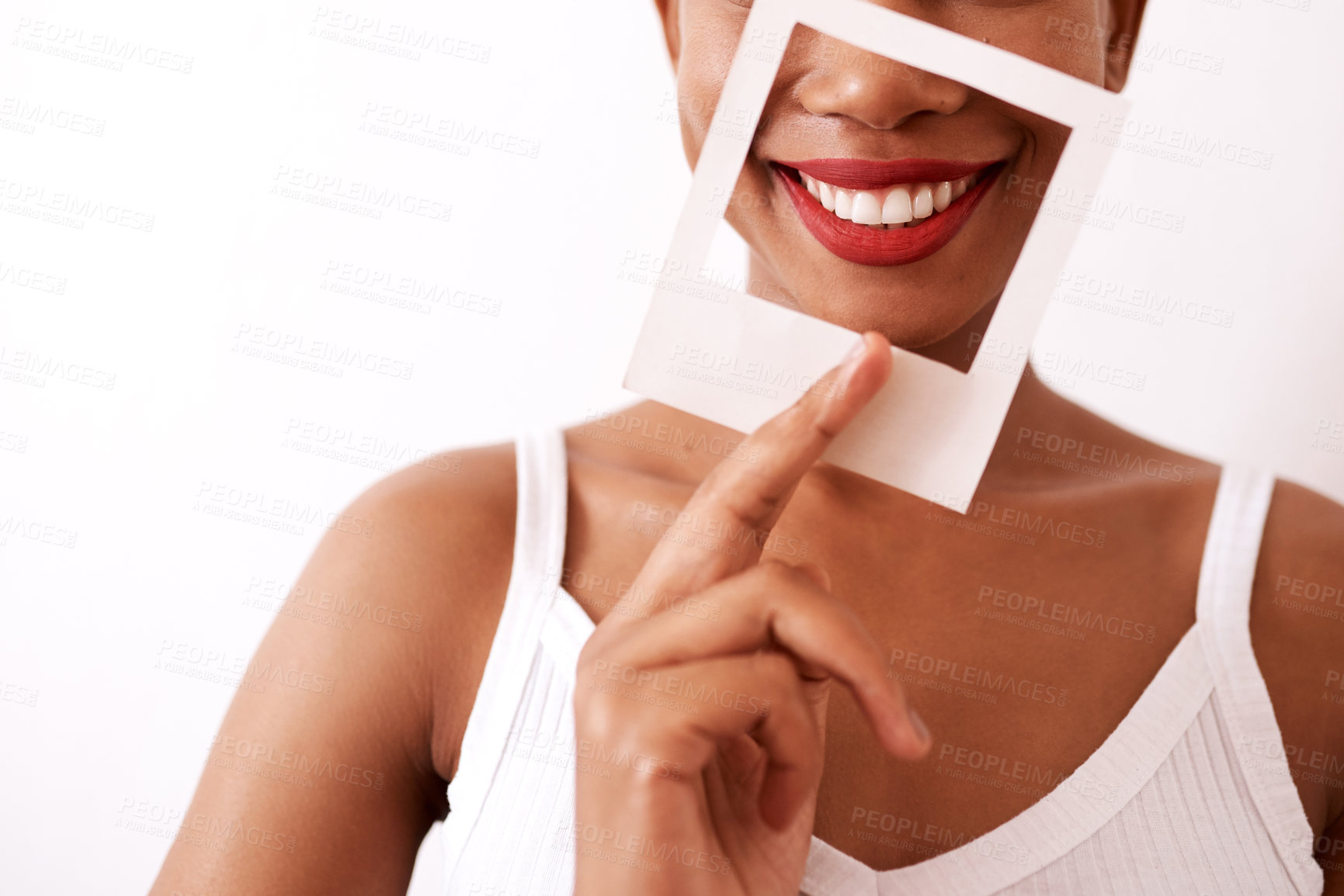 Buy stock photo Studio shot of an unrecognizable woman holding a frame over her red lips
