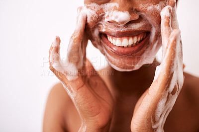 Buy stock photo Studio shot of an unrecognizable woman washing her face against a white background