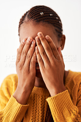 Buy stock photo Studio shot of a woman holding her hands over her face while standing against a white background