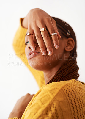 Buy stock photo Studio shot of a woman holding her hand over her face while posing against a white background