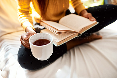 Buy stock photo Cropped shot of an unrecognizable man reading a book while sitting on her bed