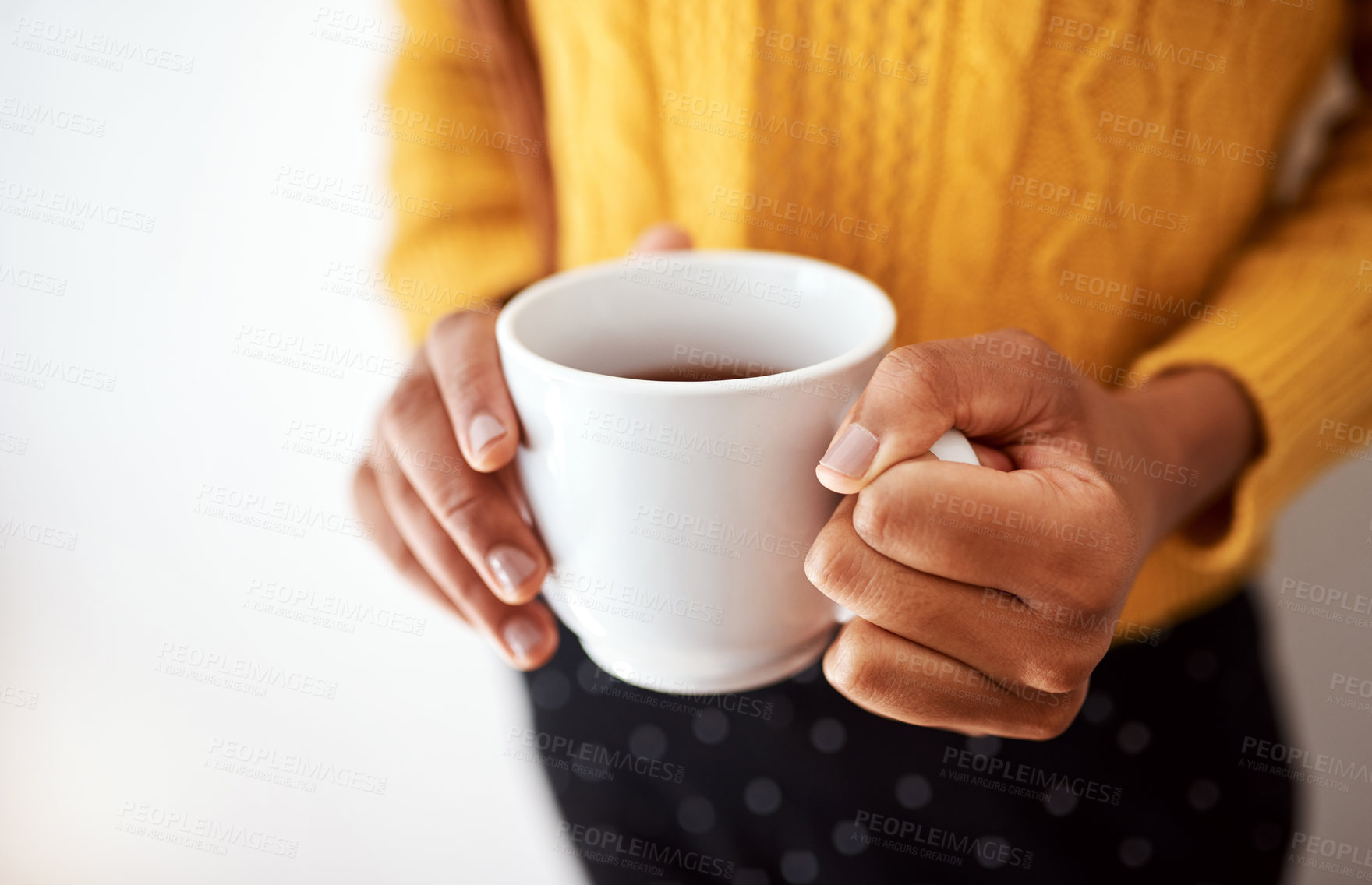 Buy stock photo Cropped shot of an unrecognizable woman holding a cup of coffee