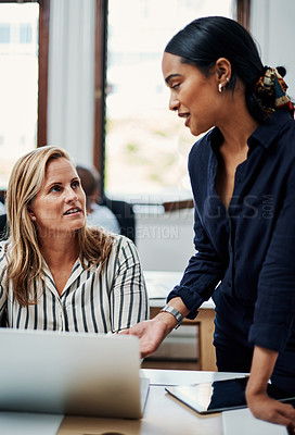 Buy stock photo Cropped shot of an attractive businesswoman helping a female colleague in the office