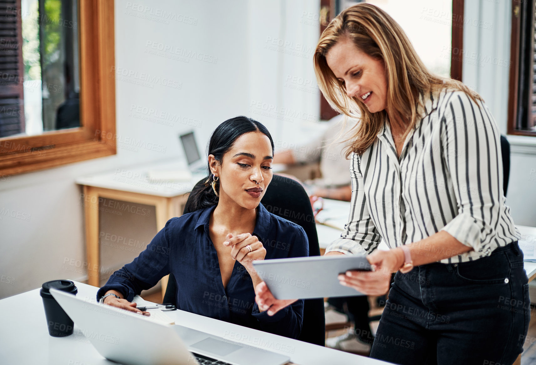 Buy stock photo Cropped shot of an attractive businesswoman helping a female colleague in the office