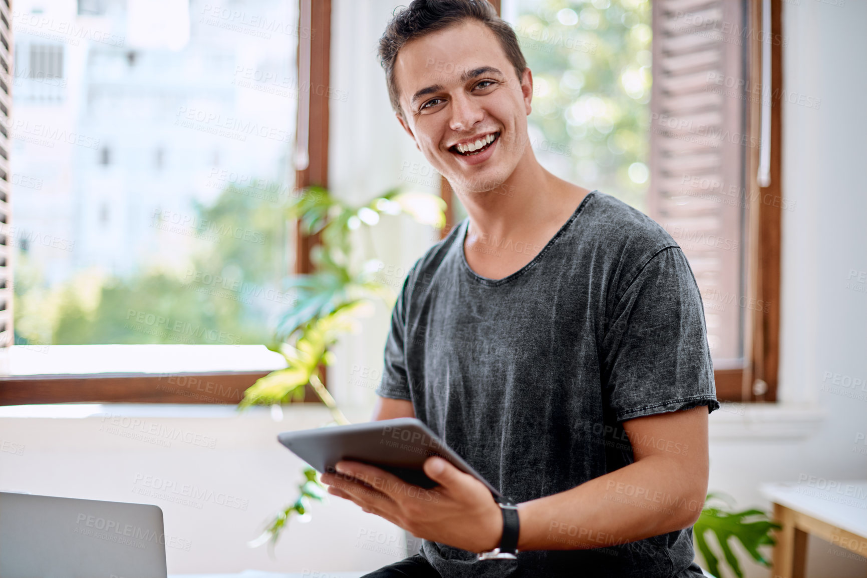 Buy stock photo Portrait of a young businessman using a digital tablet in an office