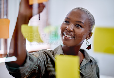 Buy stock photo Shot of a young businesswoman writing notes on a glass wall in an office