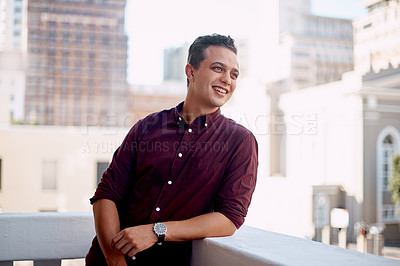 Buy stock photo Shot of a young businessman standing outside on the balcony of an office