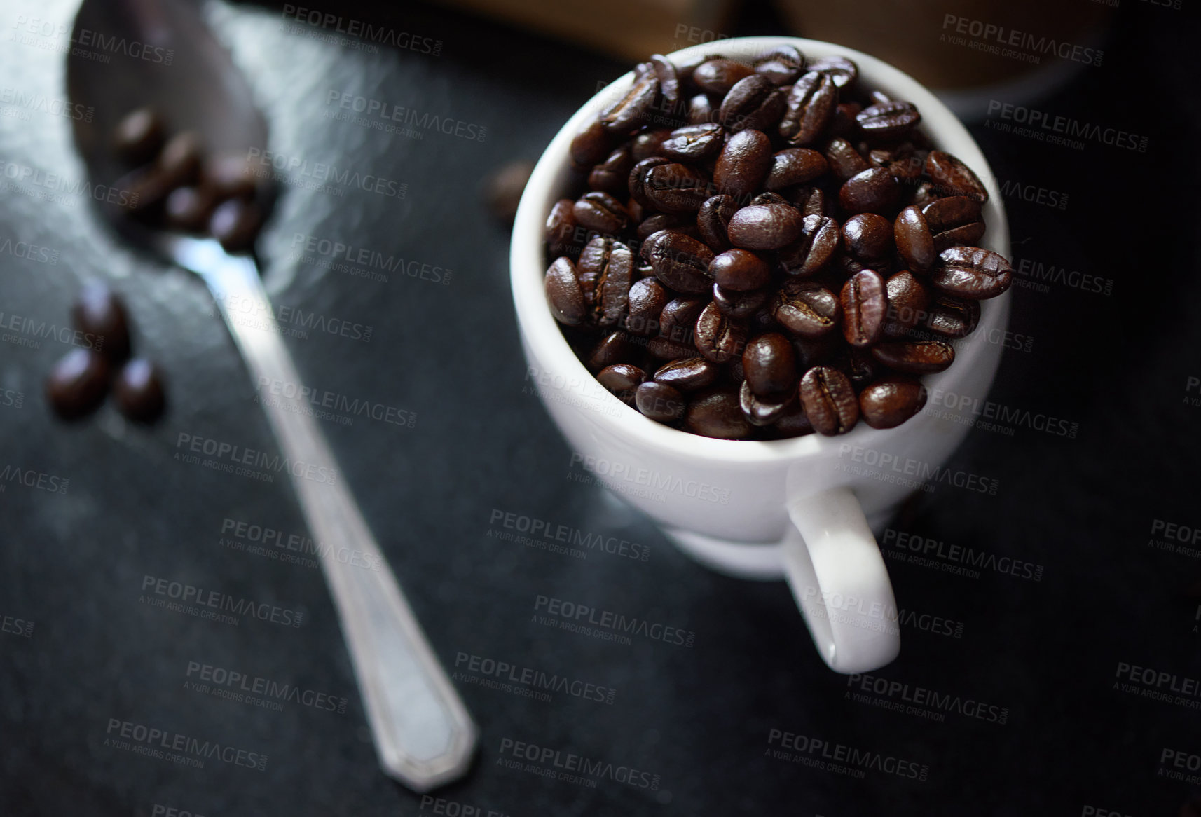 Buy stock photo Studio shot of coffee beans in a cup and on a spoon