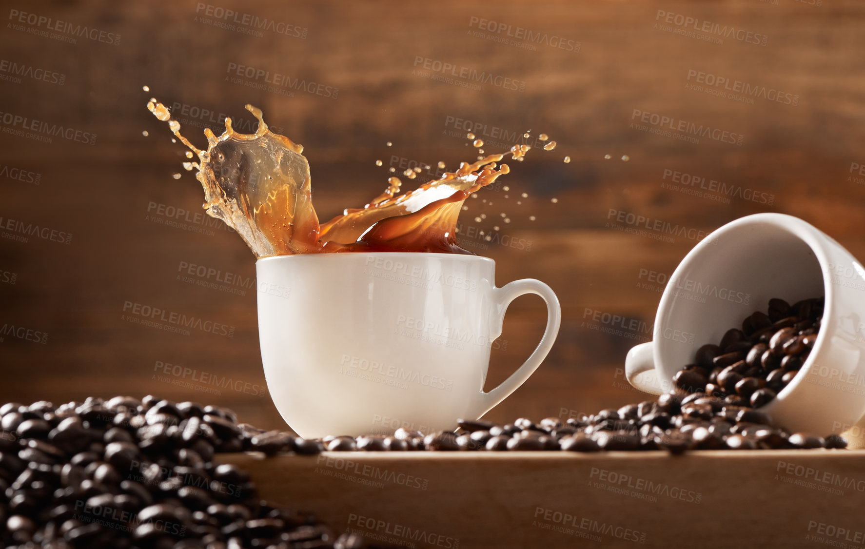 Buy stock photo Shot of a two cups against a wooden background filled with coffee and coffee beans