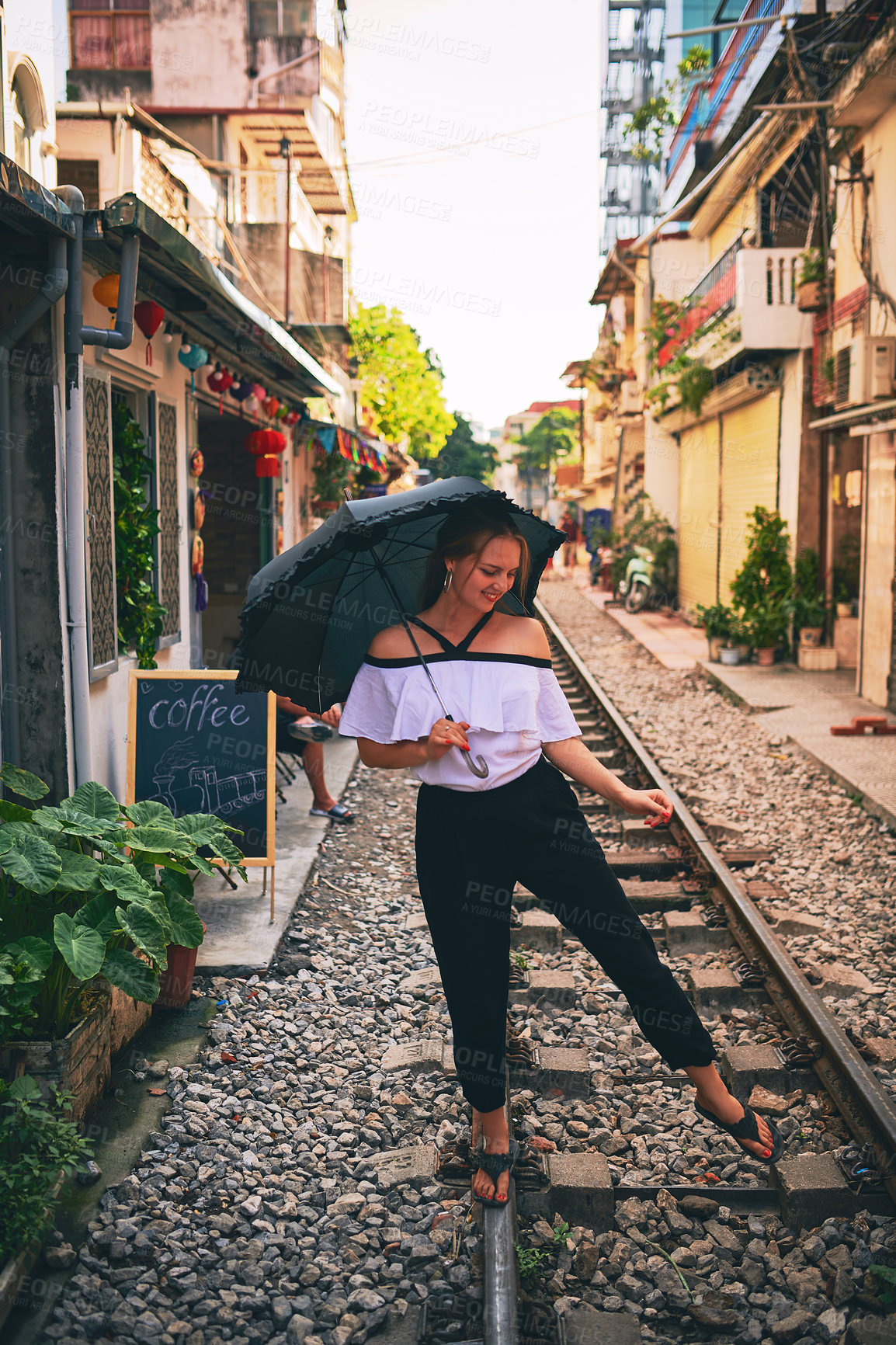 Buy stock photo Happy woman, umbrella and railway in city for vacation, explore and sightseeing with freedom. Female person, travel and excited on train track for holiday destination, adventure or outdoor in Vietnam