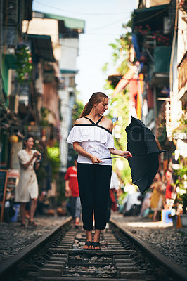 Buy stock photo Happy woman, umbrella and railway in city for sightseeing, explore and vacation with freedom. Female person, travel and excited on train track for holiday destination, adventure or outdoor in Vietnam