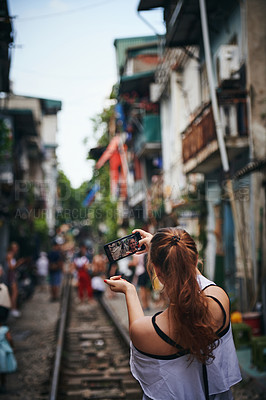Buy stock photo Cropped shot of a young woman taking selfies while exploring a foreign city
