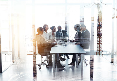 Buy stock photo Shot of a team of businesspeople in a meeting superimposed over a build site