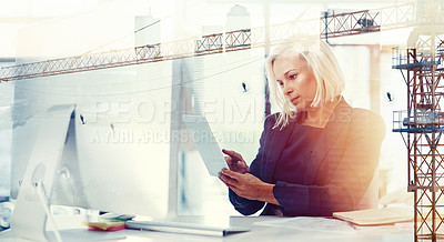 Buy stock photo Shot of a businesswoman at her desk superimposed over a cityscape