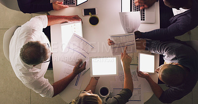 Buy stock photo High angle shot of a group of businesspeople working together around a table in their office