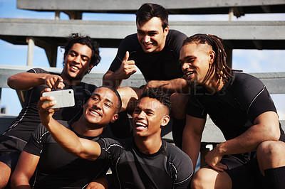 Buy stock photo Shot of a young man taking a selfie with his team mates at a rugby game