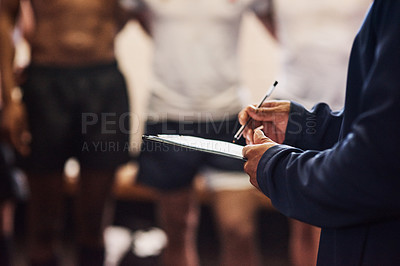 Buy stock photo Cropped shot of a rugby coach addressing his team players in a locker room