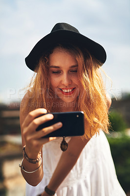 Buy stock photo Cropped shot of a young woman taking pictures on her cellphone while out in the city