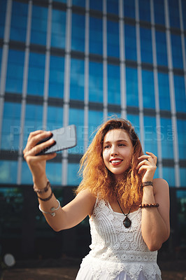 Buy stock photo Cropped shot of a beautiful young woman taking selfies while out in the city