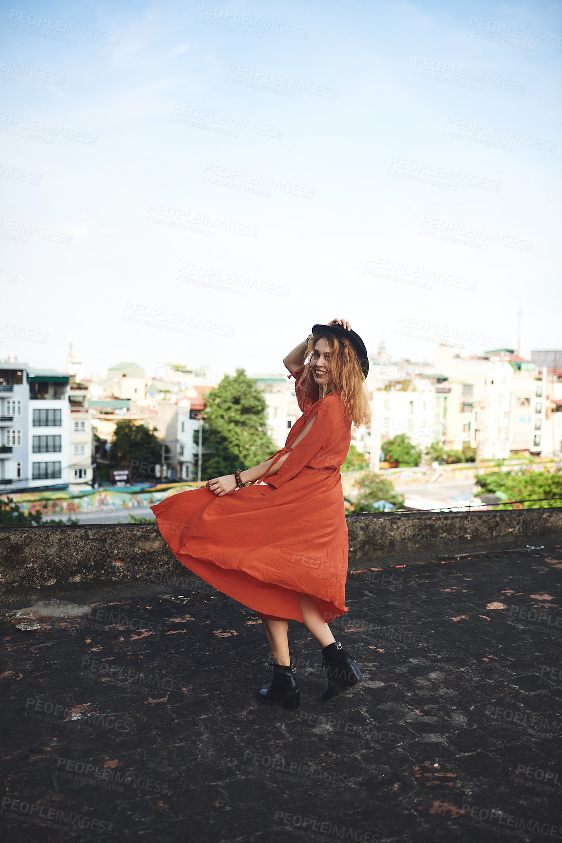 Buy stock photo Shot of a beautiful young woman posing on the rooftop of a building