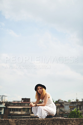 Buy stock photo Shot of a beautiful young woman out on a rooftop in the city