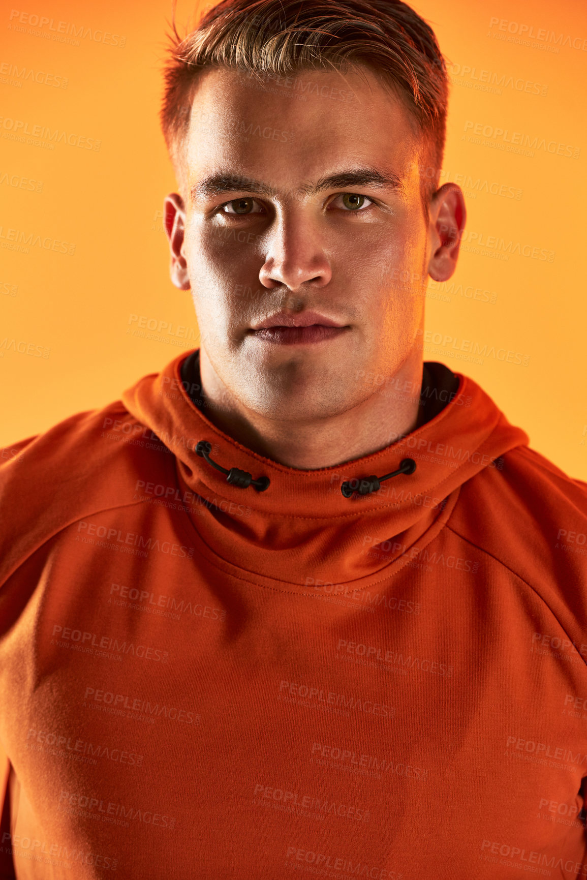 Buy stock photo Studio portrait of a handsome young male athlete posing against an orange background