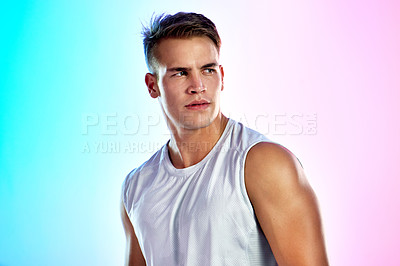 Buy stock photo Studio shot of a handsome young male athlete posing against a multi-coloured background