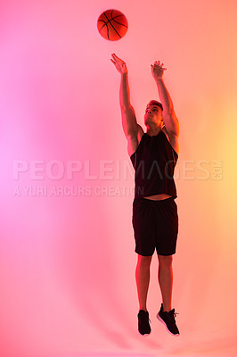 Buy stock photo Studio shot of a handsome young male basketball player taking a jump shot against a multi-coloured background