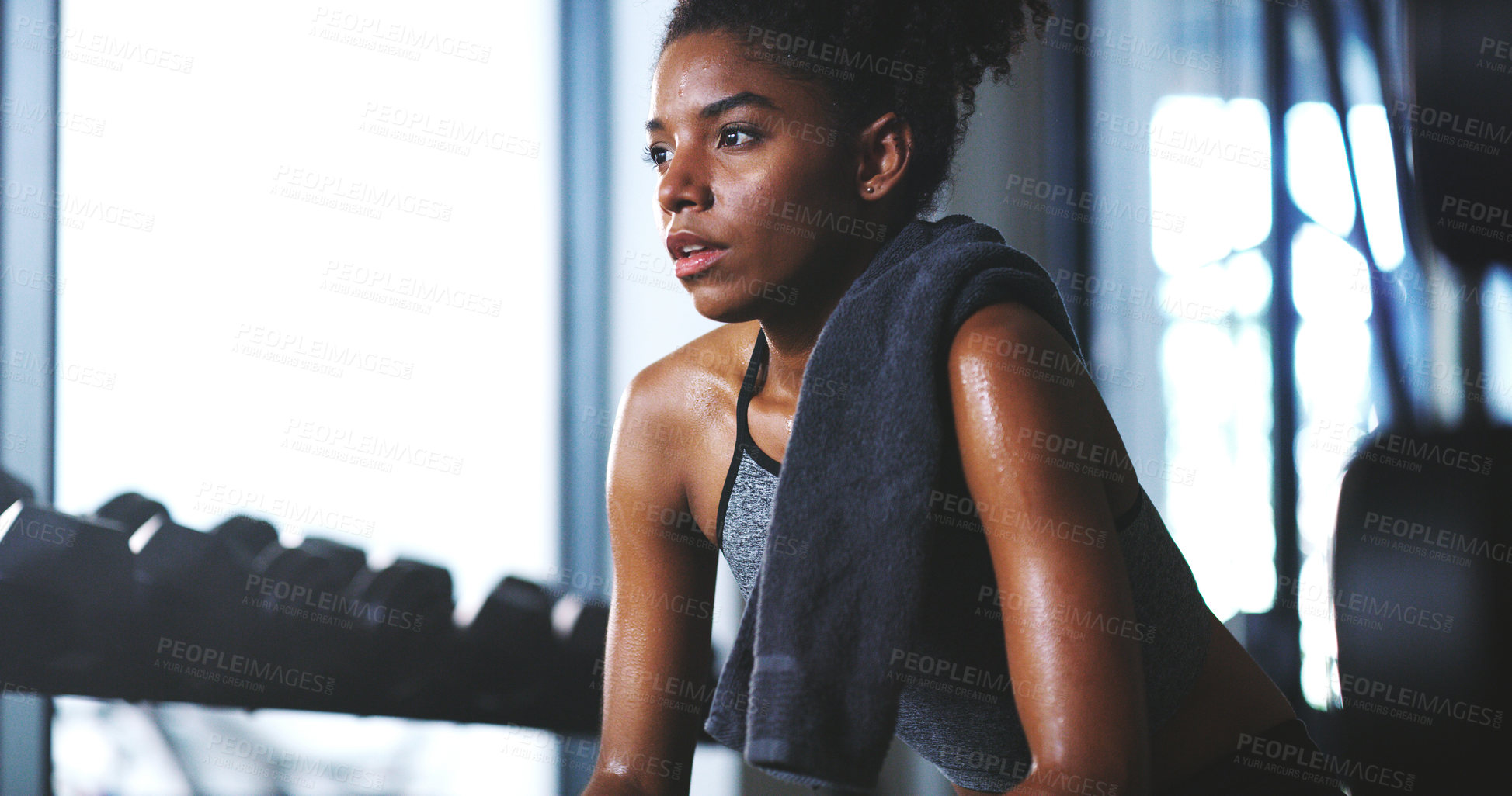 Buy stock photo Shot of a sporty young woman taking a break while exercising at the gym