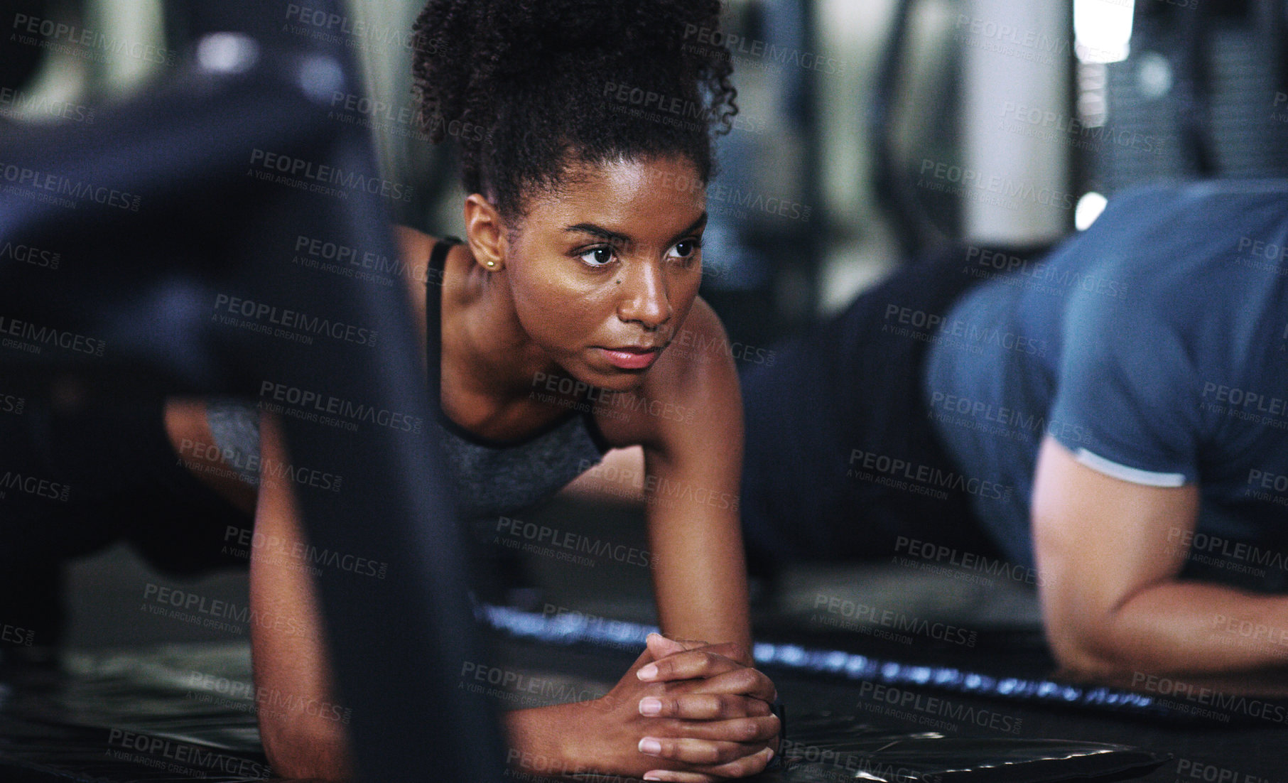 Buy stock photo Shot of a sporty young woman doing plank exercises at the gym