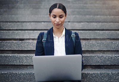 Buy stock photo Shot of a young businesswoman using a laptop on the stairs against a city background