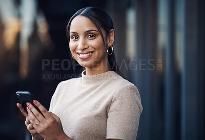 Buy stock photo Cropped portrait of an attractive young businesswoman sending a text while working in her office