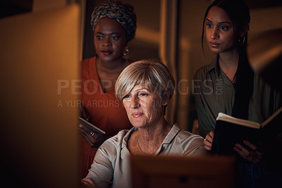Buy stock photo Shot of a group of businesswomen working together on a computer in an office at night