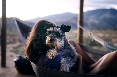 Buy stock photo Shot of a young woman relaxing with her adorable dog in a hammock