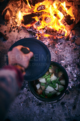 Buy stock photo Cropped shot of a man cooking traditional South African food by campfire outdoors