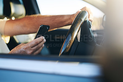 Buy stock photo Shot of an unrecognisable man using a smartphone while driving a car