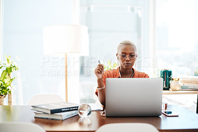 Buy stock photo Shot of a young businesswoman wearing earphones while working on a laptop in an office