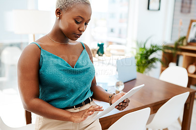 Buy stock photo Shot of a young businesswoman using a digital tablet in a modern office