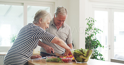 Buy stock photo Cropped shot of a happy senior couple preparing a salad together at home