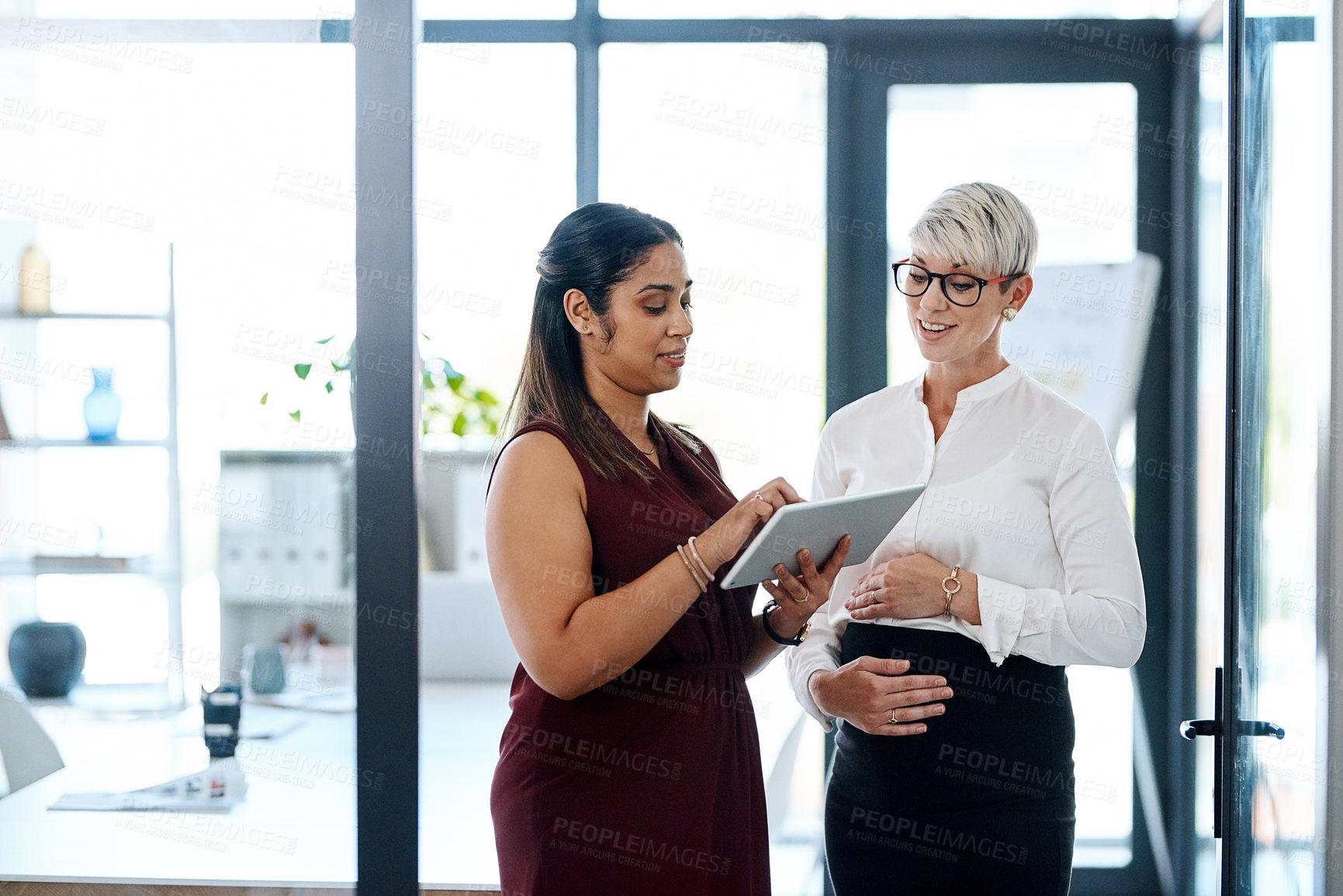 Buy stock photo Research, meeting and business women on tablet in office for discussion, talking and teamwork. Career, corporate and pregnant woman and worker on digital tech for project, online website and proposal