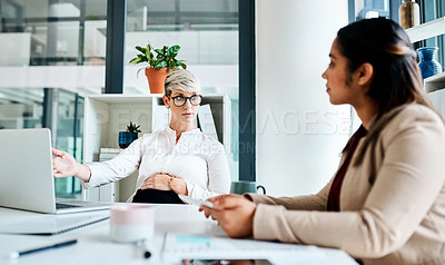 Buy stock photo Shot of a pregnant businesswoman having a discussion with her colleague in an office