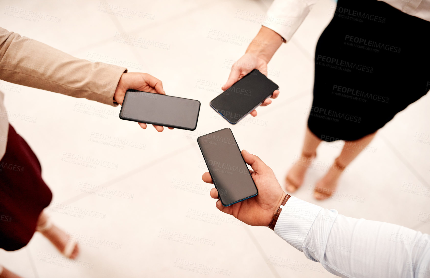 Buy stock photo Closeup shot of a group of unrecognisable businesspeople holding cellphones