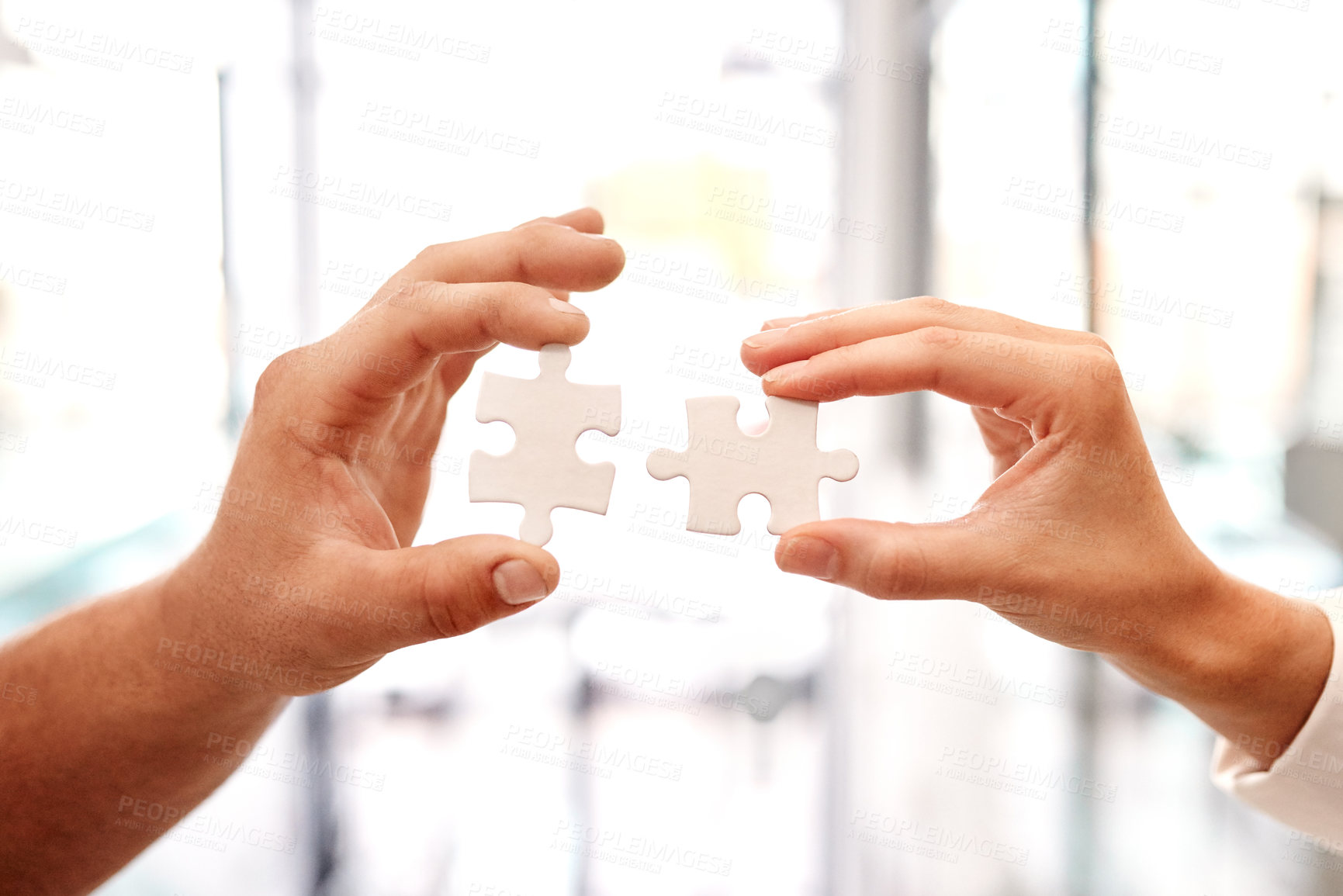 Buy stock photo Closeup shot of two unrecognisable businesspeople holding puzzle pieces together