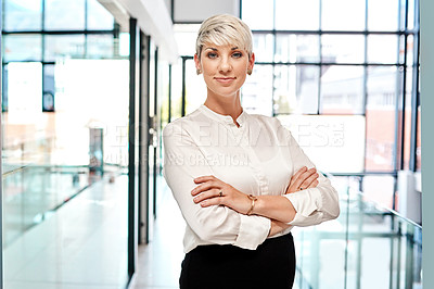 Buy stock photo Portrait of a young businesswoman standing with her arms crossed in an office