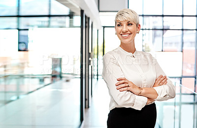 Buy stock photo Shot of a young businesswoman standing with her arms crossed in an office