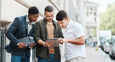 Buy stock photo Team of creative designers checking a website for ux and ui while working for a startup. Group of young guys looking at a homepage on a tablet while developing a new business strategy or mission